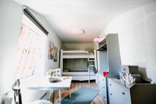 a small bedroom with a bunk bed and a desk at Ferienwohnung Waldgasthaus Armeleuteberg in Wernigerode