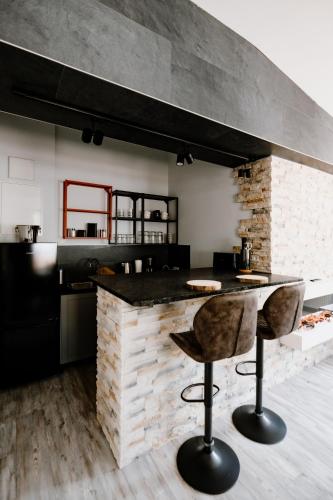 a kitchen with a counter and a bar with two stools at Ferienwohnung Waldgasthaus Armeleuteberg in Wernigerode