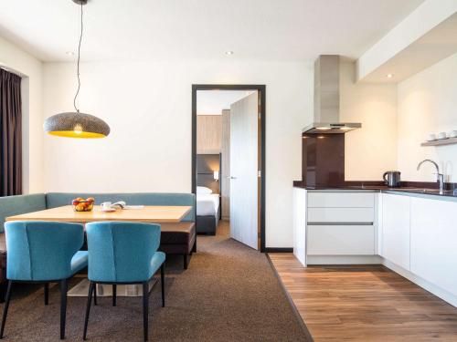 a kitchen and dining room with a table and chairs at Adagio Amsterdam City South in Amstelveen