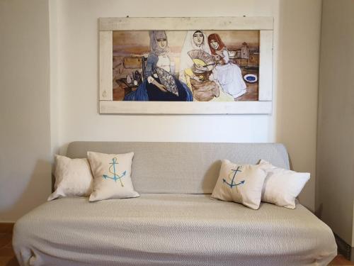 un divano con cuscini e un dipinto sul muro di Capo Figari 9, appartamento a Golfo Aranci a Golfo Aranci