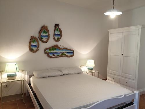 a bedroom with a bed and two mirrors on the wall at Capo Figari 9, appartamento a Golfo Aranci in Golfo Aranci