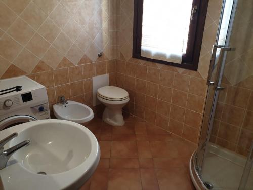 a bathroom with a sink and a toilet and a shower at Capo Figari 9, appartamento a Golfo Aranci in Golfo Aranci