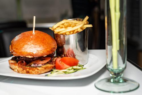 a sandwich and french fries on a plate on a table at Arany Apartman Miskolc in Miskolc