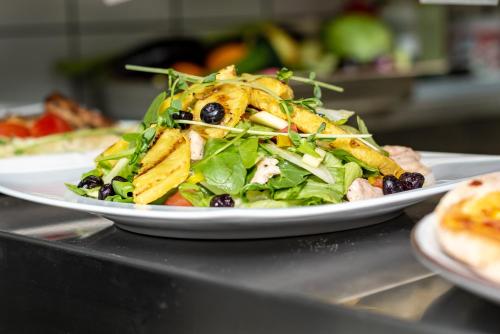 a salad on a white plate on a counter at Arany Apartman Miskolc in Miskolc