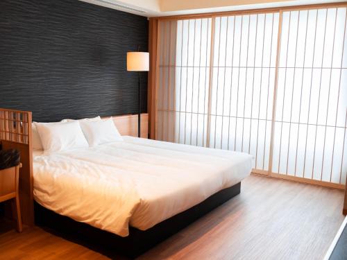 Postel nebo postele na pokoji v ubytování Hakodate Yunokawa Onsen Umi to Akari Hewitt Resort