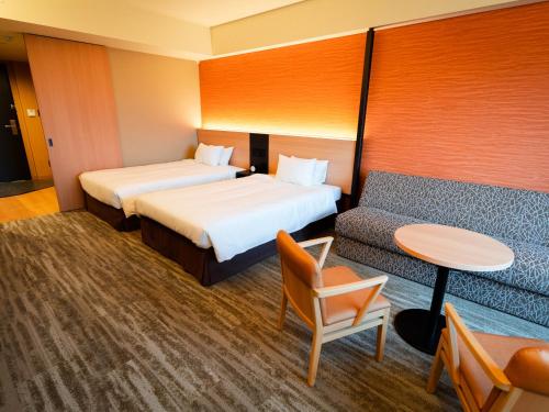 Postel nebo postele na pokoji v ubytování Hakodate Yunokawa Onsen Umi to Akari Hewitt Resort