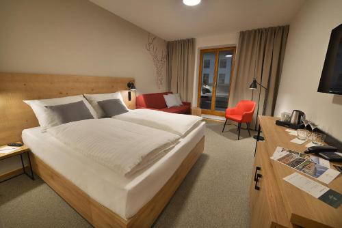 a hotel room with a large bed and a desk at Hotel Element in Lipno nad Vltavou