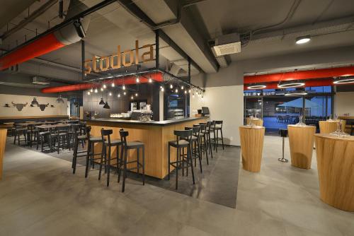 a restaurant with a bar with stools at Hotel Element in Lipno nad Vltavou
