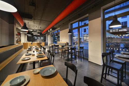 a restaurant with wooden tables and chairs and windows at Hotel Element in Lipno nad Vltavou