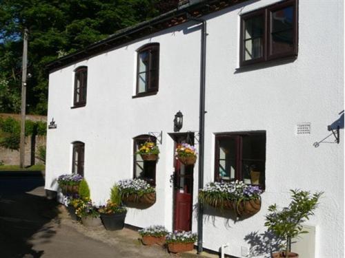 a white house with flowerpots on the side of it at Shepherds Row Bed and Breakfast in West Haddon