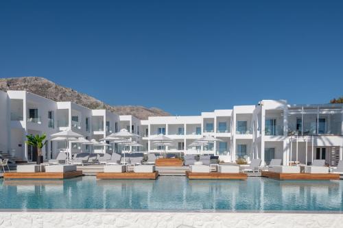a resort with a swimming pool with chairs and umbrellas at Kantouni Beach Boutique Hotel in Panormos Kalymnos