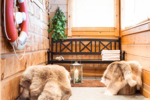 two dogs in a room with a bench and a window at Lapland Hotels Ounasvaara Chalets in Rovaniemi