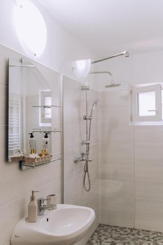 a white bathroom with a shower and a sink at Class Apartments in Oradea