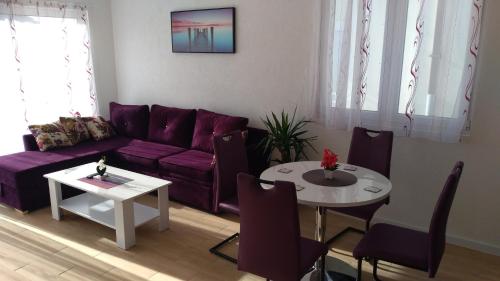 a living room with a purple couch and a table at Apartmani Marojević, Bar in Bar
