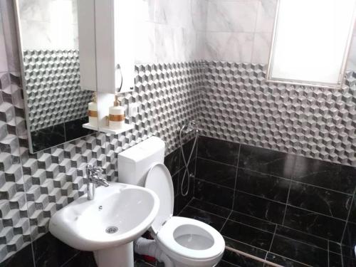 a bathroom with a white toilet and a sink at Apartmani Marojević, Bar in Bar