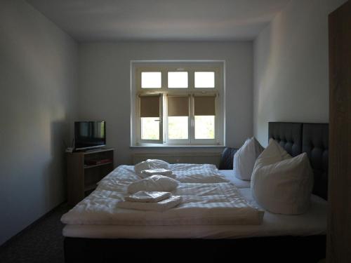 a bedroom with a bed with white sheets and a window at Ferienwohnung MIWE Gesundheitszent in Forst