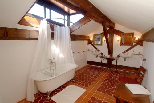 a bathroom with a tub and two sinks and a window at Pavillon de Beauregard in Aix-en-Provence