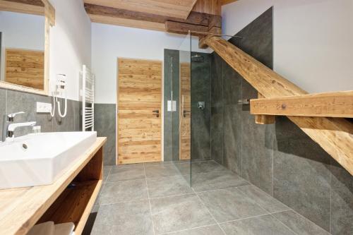 サン・ジャコモにあるTischlerhof Alpine Livingの洗面台とガラスのシャワーを備えたバスルーム