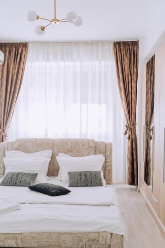 a bedroom with a bed with a large window at Class DeLuxe Apartments in Oradea