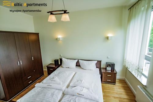 1 Schlafzimmer mit 2 Betten und einem großen Fenster in der Unterkunft Baltic Apartments - Bałtycka in Świnoujście