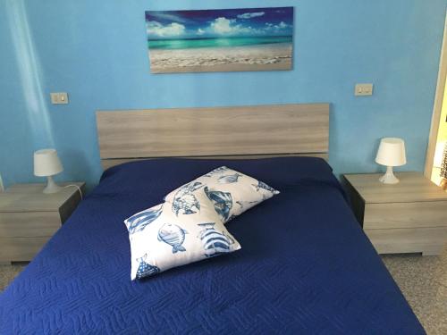 - une chambre bleue avec un lit et 2 tables de chevet dans l'établissement Appartamento il delfino, à Lido di Camaiore