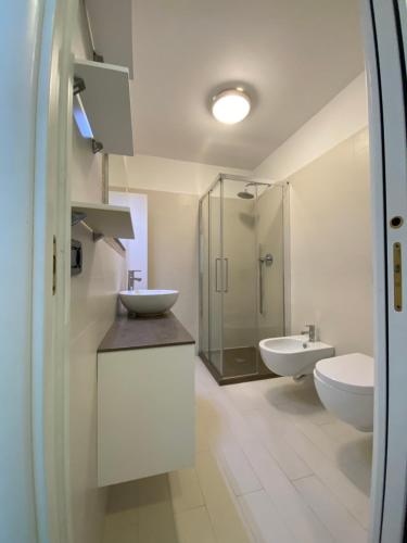 a white bathroom with two sinks and a shower at Mansfield vue carte Postale Terrasse Piscine calme port à 200m à pied in Menton