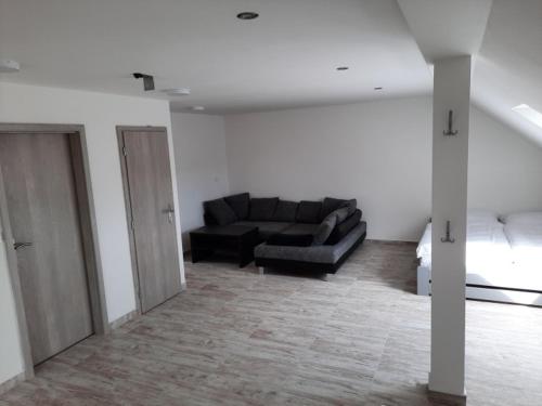 a living room with a black couch in a room at Apartmán Vimperk in Vimperk