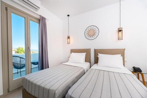 dwa łóżka w pokoju z oknem w obiekcie Kalisperis Hotel w mieście Mesaria