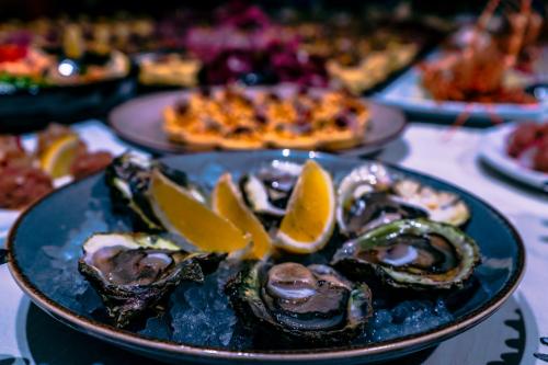 a plate of oysters and lemon slices on a table at Leonis Restaurant & Rooms in Split