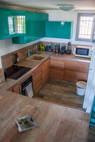 une cuisine avec des armoires vertes et un évier dans l'établissement Appart terrasse, Climatisation , Vue mer, Parking, à La Seyne-sur-Mer