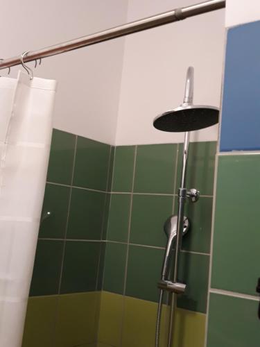 a bathroom with a shower with green tiles at Wioska pod Kogutem in Krępa