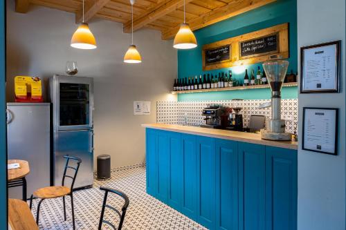 a blue kitchen with a counter and a table and chairs at Myrtus Borbár és Vendégház in Tarcal