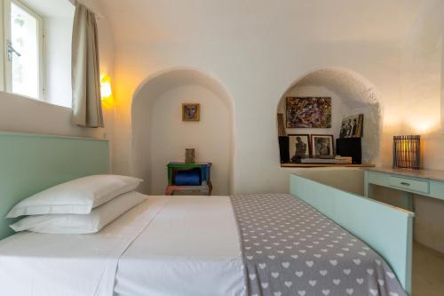 ein Schlafzimmer mit einem großen weißen Bett in einem Zimmer in der Unterkunft Dimora Santi-Mancuso by BarbarHouse in Presicce