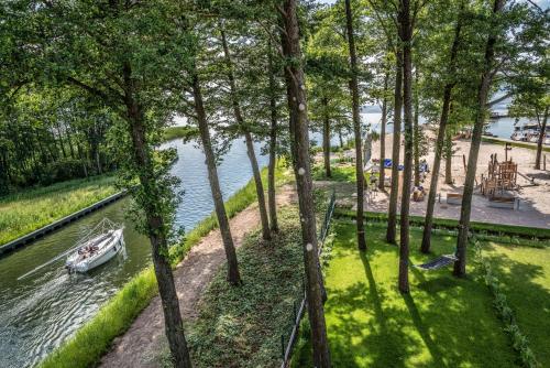 a boat in the water in a park with trees at Nautica Resort in Giżycko
