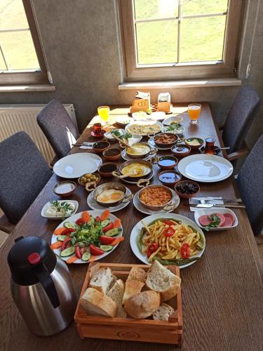 een houten tafel met borden met eten erop bij Kaya Life Resort in Uzungol
