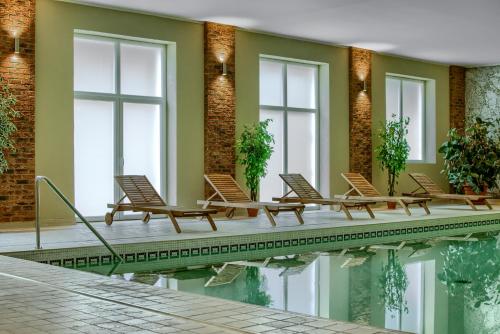 a row of chairs sitting next to a swimming pool at Kadyny Folwark Hotel & SPA in Kadyny