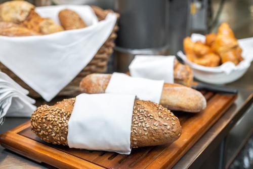 a bunch of bread on a cutting board with rolls at Hotel Hofgarten Luzern in Luzern
