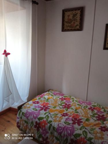 a bedroom with a bed with a flowered blanket at CASA DOS GRILOS in Penacova