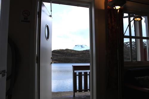 a door leading into a room with a view of a lake at Sildpollnes Sjøcamp in Vestpollen