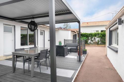 une pergola sur une terrasse avec une table et des chaises dans l'établissement Maison pour 6. Pornic 700m de la plage, à Pornic