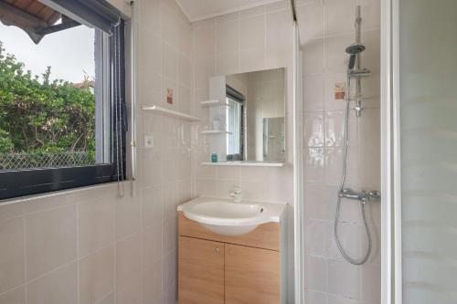 une salle de bain avec un lavabo et une douche avec un miroir dans l'établissement Maison pour 6. Pornic 700m de la plage, à Pornic