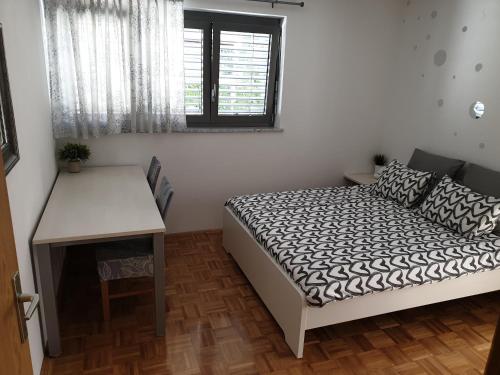 a bedroom with a bed and a desk and a window at Apartment EMMA Ljubljana - FREE parking, AC, Wifi in Ljubljana