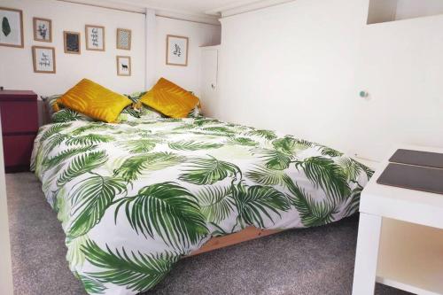 Un dormitorio con una cama con hojas de palmera. en Cute & Cosy Loft-Style Studio close to Beach, en Bournemouth