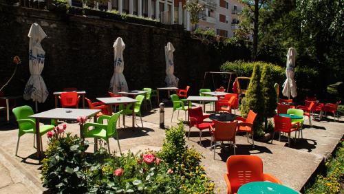 a group of tables and chairs in a garden at Alvero Hotel in Përmet