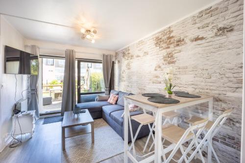 un salon avec un canapé bleu et une table dans l'établissement Galene, à Courseulles-sur-Mer