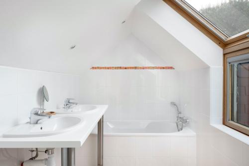 a white bathroom with a sink and a bath tub at À 200m du Port de Crouesty, Maison 6 personnes in Arzon