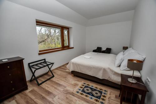a bedroom with a bed and a window at Bodrog33 Riverhouse in Tokaj