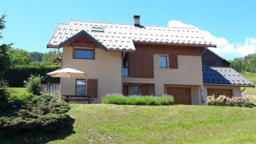 une maison sur une colline avec un parasol dans l'établissement Le Maurillon, à Saint-Pancrace