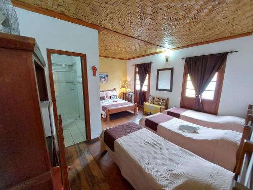 a hotel room with two beds and a bathroom at Pousada Estação do Trem in São João del Rei
