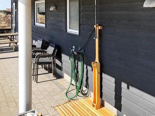 a green hose is on the side of a house at 22 person holiday home in Harbo re in Harboør
